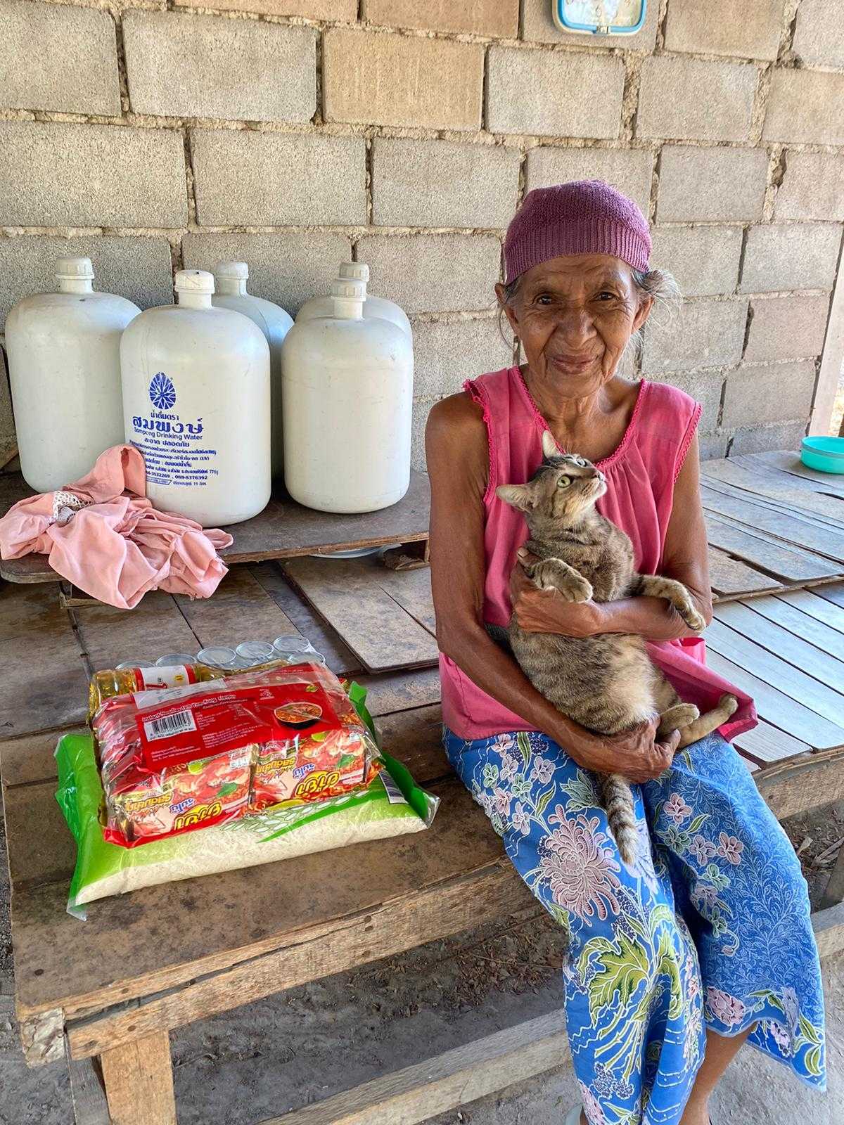 elderly woman with cat and food package